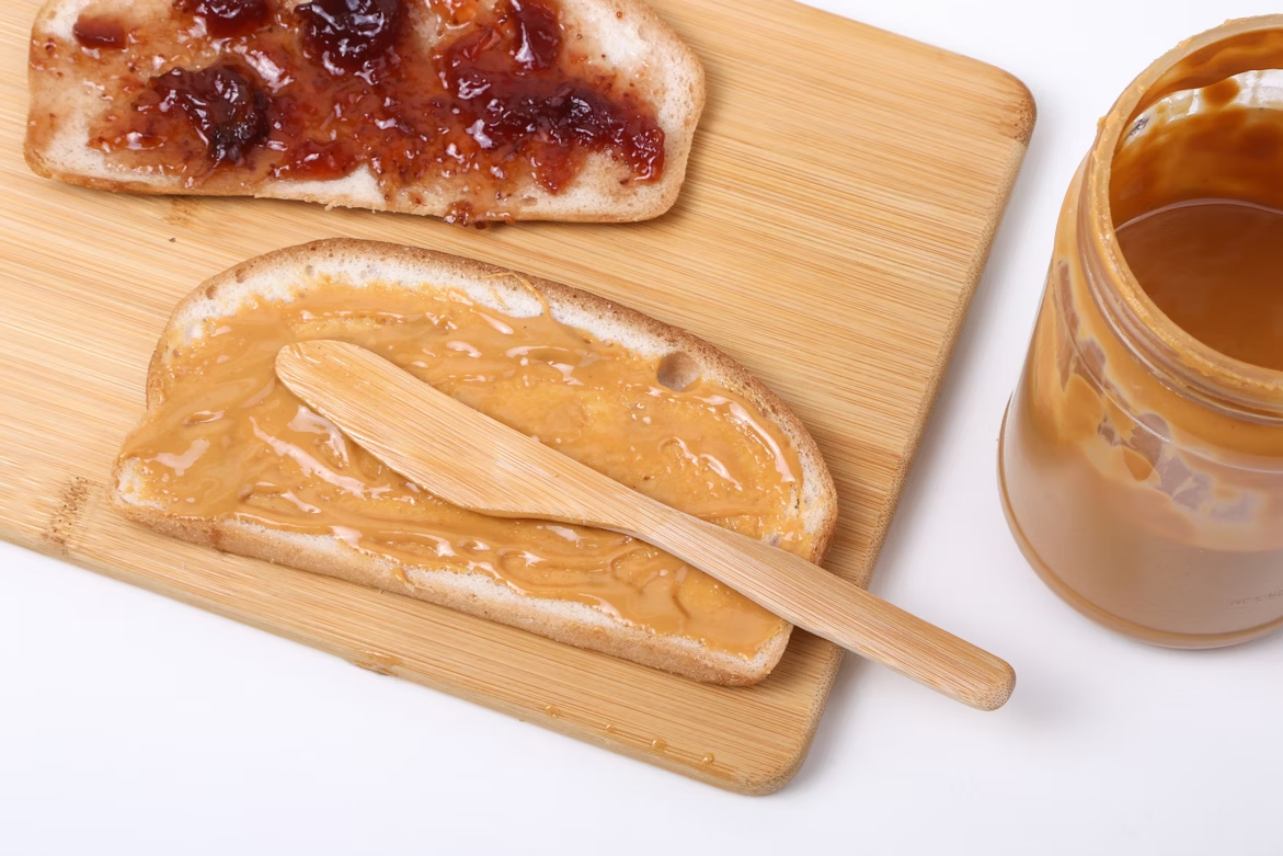 Slices of bread with peanut butter and jelly, showing the classic PB&J food pairing.