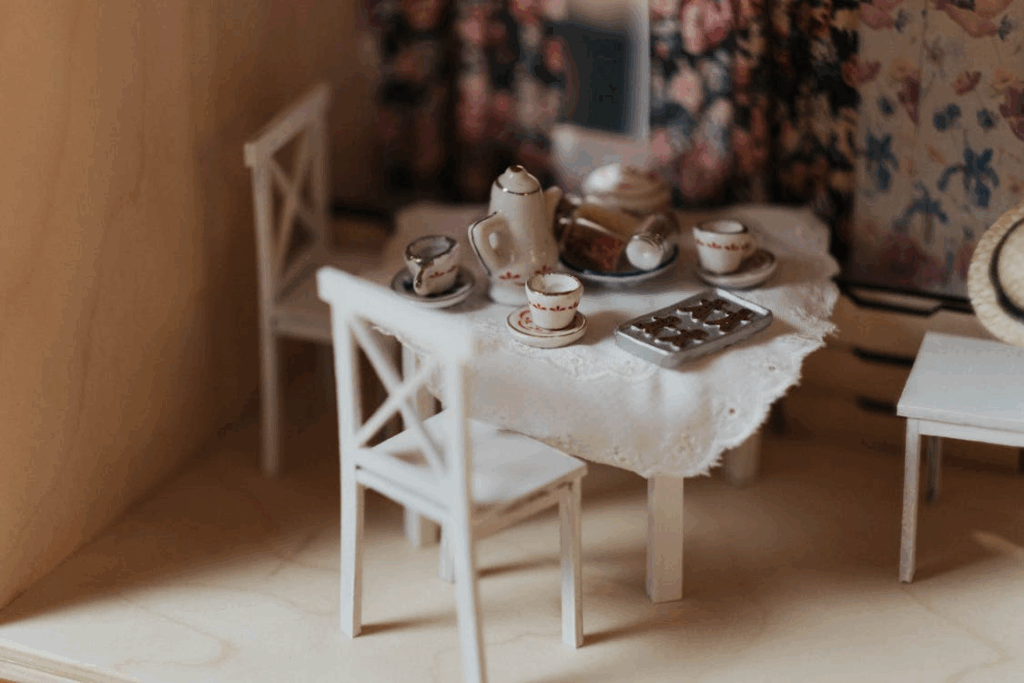 Miniature dollhouse table with tiny tea set, a nostalgic scene illustrating the psychology of miniatures.