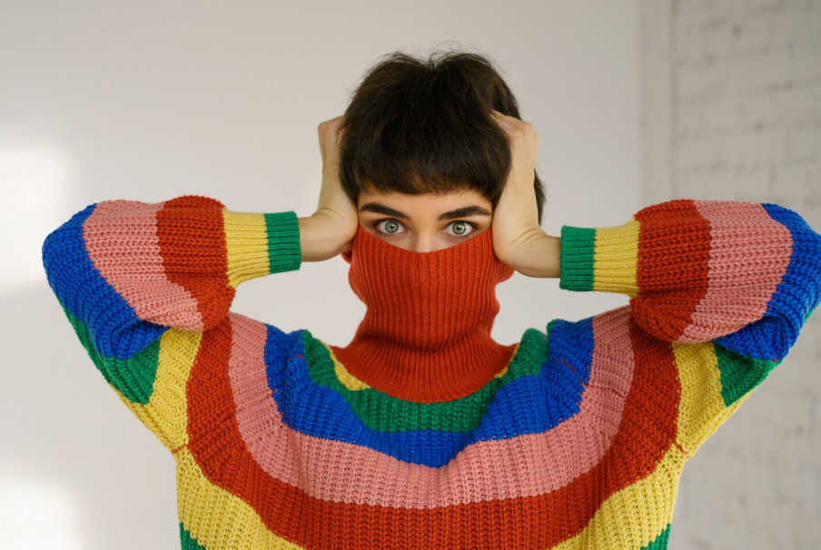 Person in a bright rainbow-striped sweater, highlighting color psychology and mood.
